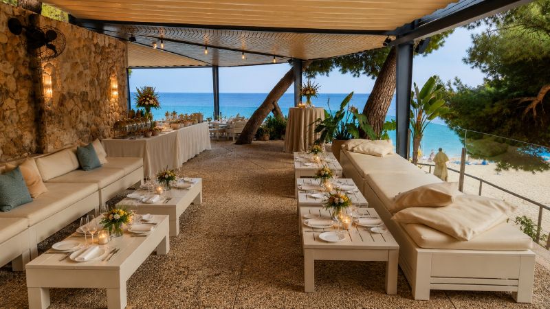 Elegante Beach Lounge auf Mallorca mit eingedeckten Tischen, mediterranem Buffet und Meerblick direkt am Strand